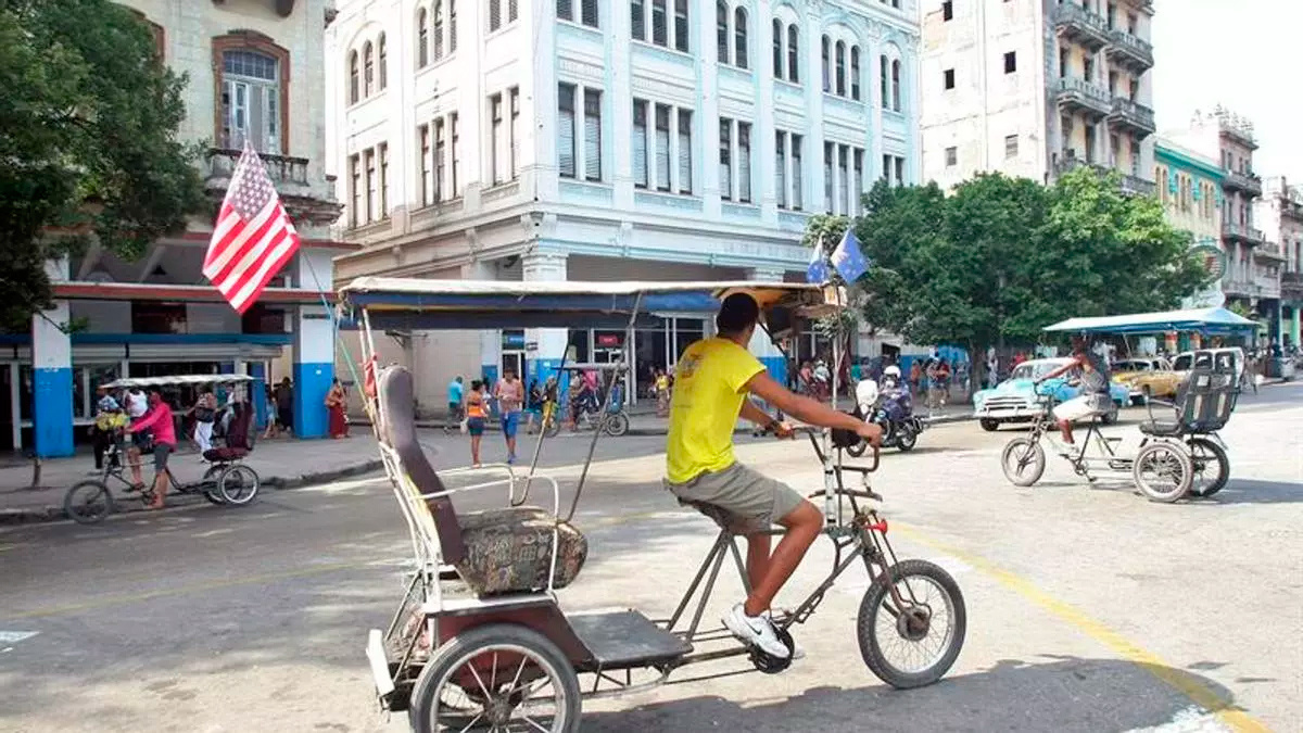 Un bicitaxi luce una bandera estadounidense por las calles de La Habana.